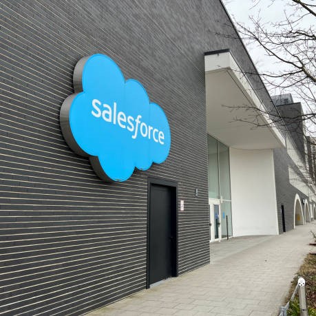 Munich, Bavaria Germany - December 20, 2021: Salesforce internet corporation brick office building with blue cloud logo, windows, and trees in Munich Germany.